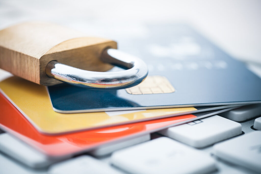 A close-up of a credit card and a padlock placed on a keyboard, representing the importance of secure online transactions.